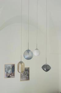 a group of lights hanging from a white wall at Nina Mia in Fasano