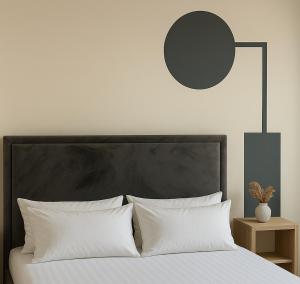 a bed with a black headboard and white pillows at Elegant Apartment - Beachside Riviera NEW in Durrës