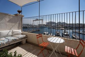 Panorama vue mer et plein centre ville في لاسيوتا: شرفة مع أريكة وكراسي وطاولة