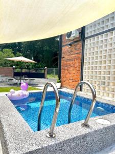 une piscine avec deux robinets en métal à côté dans l'établissement Kurie Redbrick House, à Balik Pulau
