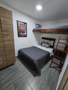 a bedroom with a bunk bed and a ladder at Apartamento Portal el Dorado, a solo 5 min del aeropuerto, vias, cll 26 in Bogotá