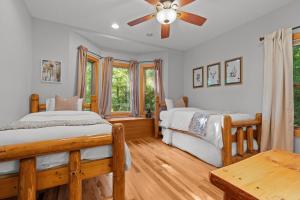 a bedroom with two beds and a ceiling fan at Luxury Cabin Hot Tub & Game Room in Franklin
