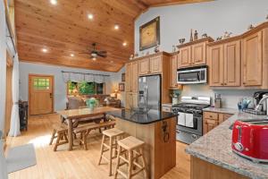 a kitchen with wooden cabinets and a table and a dining room at Luxury Cabin Hot Tub & Game Room in Franklin