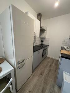 a kitchen with a white refrigerator and a wooden floor at 29 Sweet 1 Bed sleeps 4 with free parking BHX NEC in Sheldon