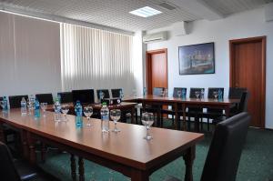 a conference room with tables and chairs with wine glasses on them at Hotel Emma Est in Craiova +74 photos