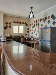 a kitchen with a granite counter top and a refrigerator at مصيف مارينا الشاطئ الأزرق in Marsa Matruh