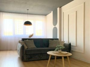 a living room with a green couch and a table at Elegant Apartment - Beachside Riviera NEW in Durrës