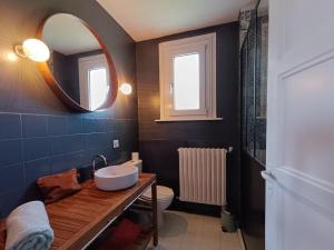 a bathroom with a sink and a mirror and a toilet at Maison plages & centre à pieds - proche GR34 in Saint-Pol-de-Léon