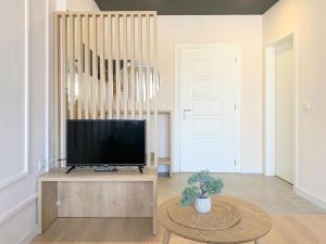 a living room with a television and a table at Elegant Apartment - Beachside Riviera NEW in Durrës