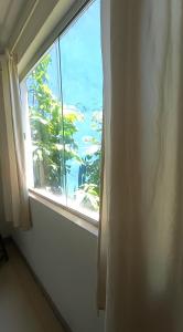 a window in a room with a view of the ocean at Apartamento Próximo a Pituba in Itacaré +3 photos