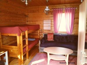 a room with a couch and a bed in a cabin at Spacious villa with great scenery and nature in Pertunmaa