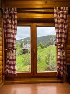 a window in a cabin with a view of a field at Brvnara Jevtic, Tara in Mokra Gora +17 photos