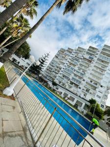 a swimming pool in front of a large apartment building at Beachfront apartment DIANA 2 in Benalmádena
