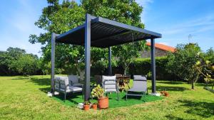 a gazebo with chairs and a table in a yard at Valdoviño Experience in Valdoviño