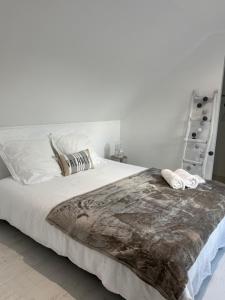 a bedroom with a large bed with two towels on it at L'Olivier de munet in Distré