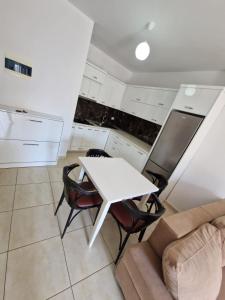 a white kitchen with a white table and chairs at Summer Apartments in Shengjin in Shëngjin