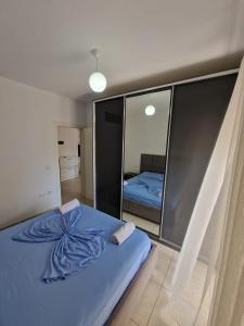 a bedroom with a blue bed and a mirror at Summer Apartments in Shengjin in Shëngjin