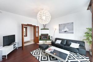 ソポトにあるImperial Apartments - Cassino Grandeのリビングルーム(黒いソファ、テレビ付)