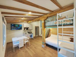 a bedroom with a bunk bed and a desk and a kitchen at Posada el Remanso de Trivieco in La Cavada
