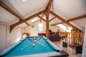 a pool table in the middle of a living room at Maison spacieuse au calme in Morcenx