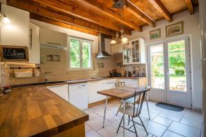 a kitchen with a table and a wooden ceiling at Maison spacieuse au calme in Morcenx