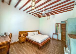 a bedroom with a bed and a wooden floor at Ananda Beach Hotel in Paje