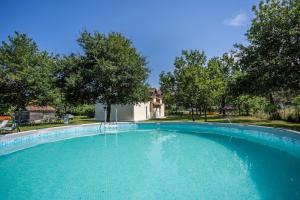 a large swimming pool in a yard with trees at Maison spacieuse au calme in Morcenx
