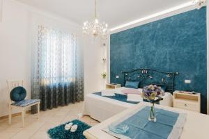 una camera da letto con un letto grande e una parete blu di B&B Le Ortensie a San Vito lo Capo