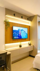 a living room with a flat screen tv on a wall at Studio completo no Daia-Anápolis em frente a Caoa in Anápolis