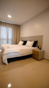 a bedroom with a large white bed with a window at Studio completo no Daia-Anápolis em frente a Caoa in Anápolis
