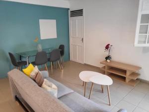 a living room with a couch and a table at Petit cocon au cœur des ABYMES in Les Abymes