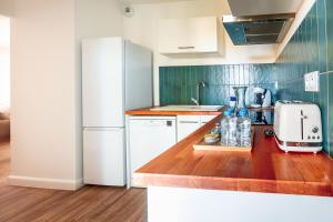 een keuken met witte apparatuur en een houten aanrecht bij Casamea - T2 A Tavagna in Talasani