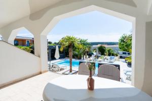 a dining room with a table and a view of a pool at Peaceful OAZA in Stara Novalja