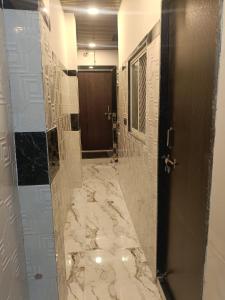 ein Badezimmer mit ebenerdiger Dusche und Marmorboden in der Unterkunft HOTEL IN UJJAIn in Ujjain