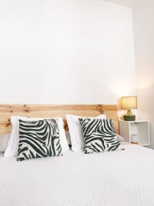 a bed with zebra pillows in a bedroom at I Loft 9 I Centro de Alcala Sevilla in Alcalá de Guadaira