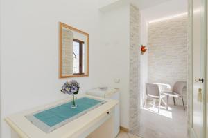 un bagno con un vaso di fiori su un bancone di B&B Le Ortensie a San Vito lo Capo Altre 52 foto