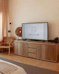 a flat screen tv sitting on top of a wooden cabinet at Beachfront Staff n Cook, Luxury 8 Bed Villa in Tulum in Balcheil +44 photos