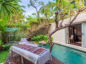 a room with a table next to a pool at Kawung Villa Canggu in Canggu
