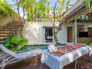 a patio with a table and chairs and a pool at Kawung Villa Canggu in Canggu