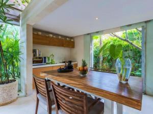 a kitchen with a wooden counter and a large window at Kawung Villa Canggu in Canggu
