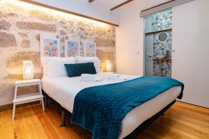a bedroom with a large bed with a blue blanket at Douro View House Ribeira in Porto