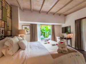 a large white bed in a room with a window at Kawung Villa Canggu in Canggu +35 photos