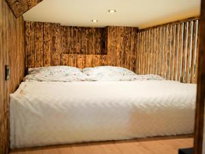 ノヴィ・ソンチにあるApartament Tokioの木製の壁のベッドルーム1室(白いベッド1台付)