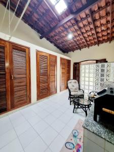 una sala de estar con un sofá y una silla en Casa encantadora 900m da PRAIA de Itaipuaçu, en Maricá