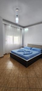 a bedroom with a bed with a blue blanket at Summer Apartments in Shengjin in Shëngjin