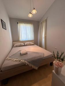 a bedroom with a large bed in front of a window at Apartmani Lucija in Zadar