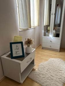 a white dresser with a sign on it with a mirror at Apartmani Lucija in Zadar +39 photos