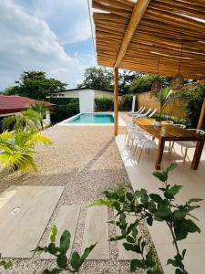 a backyard with a wooden table and a pool at Casa Ophelia in Tamarindo