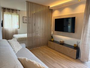 a living room with a couch and a flat screen tv at Romance Marine , face à la mer in Villeneuve-Loubet