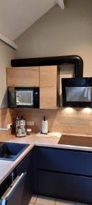 a kitchen with a counter top with a microwave at Maison Aunais in Mormont-La-Grande